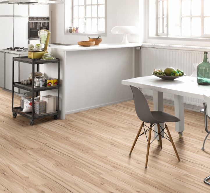 Modern kitchen with Oak Memory sanded Chalet flooring, white countertops, and a gray chair.