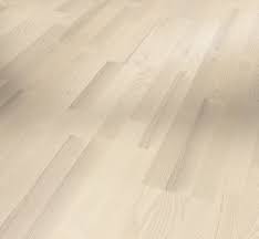 Close-up image of white engineered wood flooring with a matte lacquer finish.