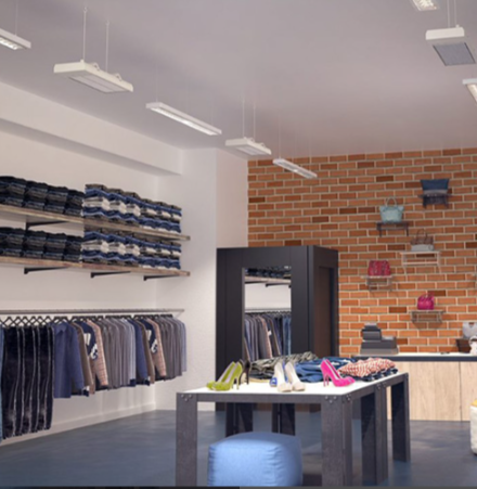 Modern clothing store interior with white Ecosun S+ heaters suspended from the ceiling in two rows. Also racks and display table.