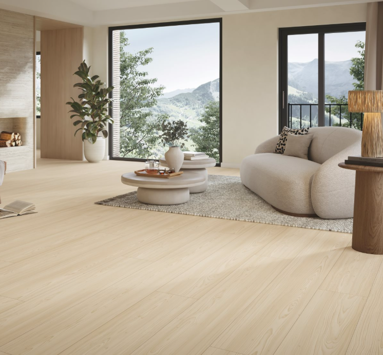 Modern living room with large Chateau plank floors, beige carpet, sofa, and large windows overlooking greenery.