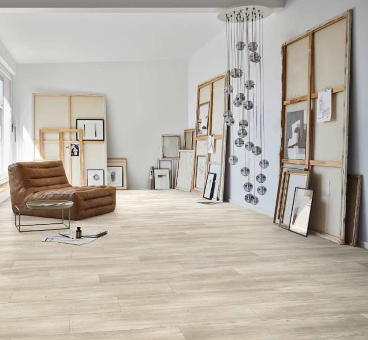 Modern living room with a brown sofa, wooden floor and wall art