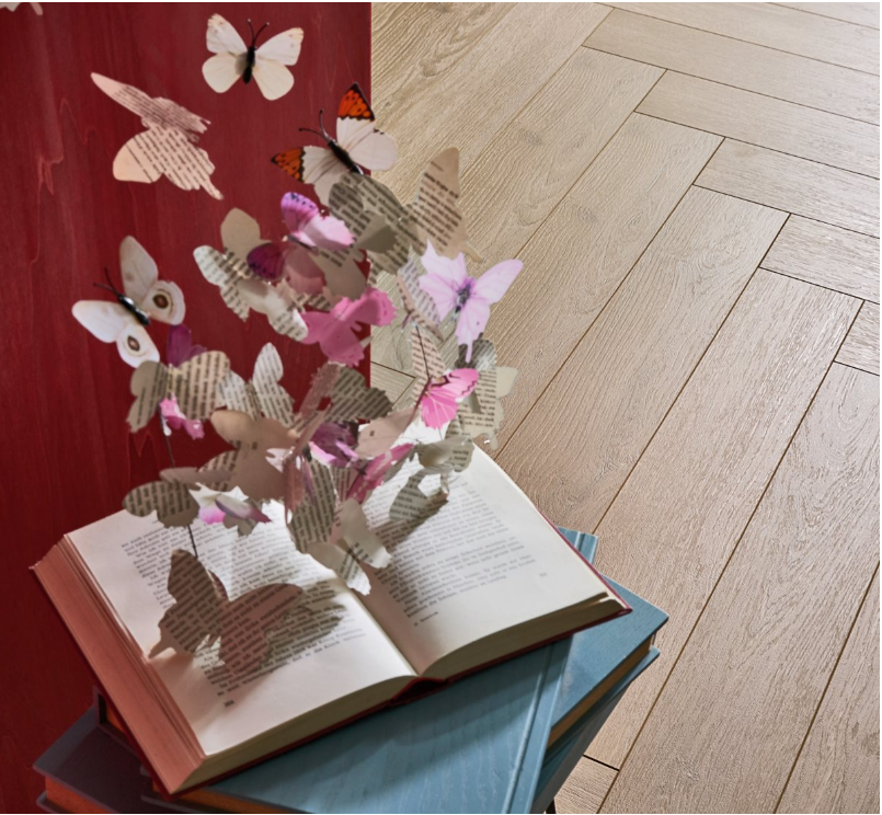 Open book with paper butterflies on a herringbone wooden floor