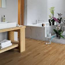 Engineered wood flooring installed in a bathroom setting, with a focus on the natural wood grain texture.