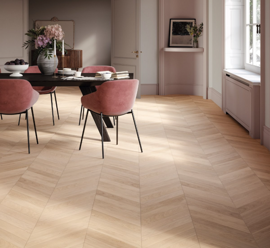 Dining room with wooden floor and pink chairs.