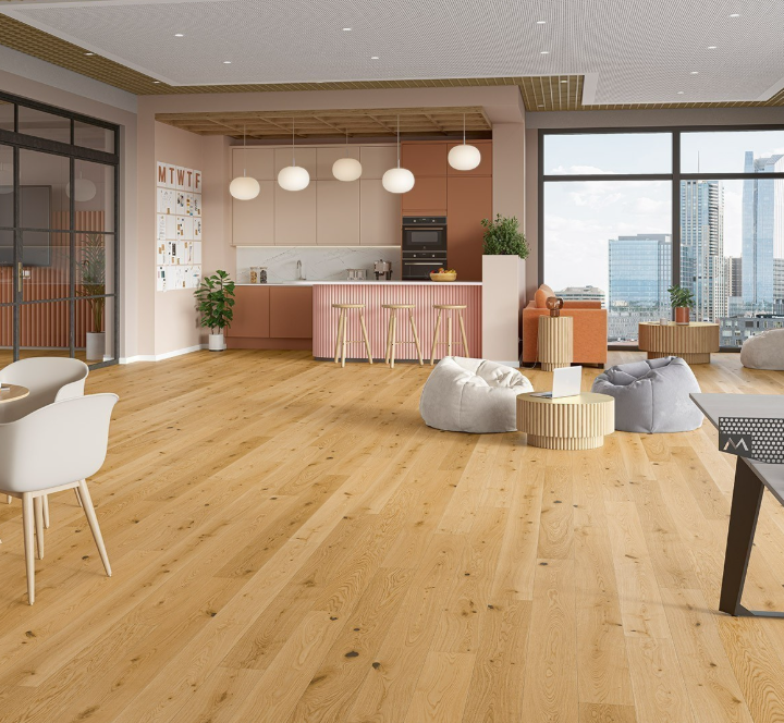 Installed flooring in a bright living room - open-plan kitchen with large windows.