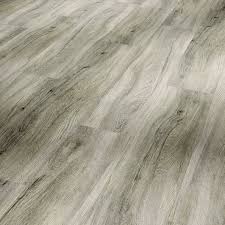 A close-up image of pastel grey wide plank vinyl flooring with a wood texture finish.