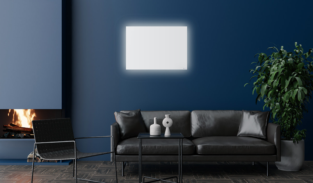 Modern living room with a dark sofa, coffee table, and decorative items against a blue wall which has an LED infrared heater on it. 