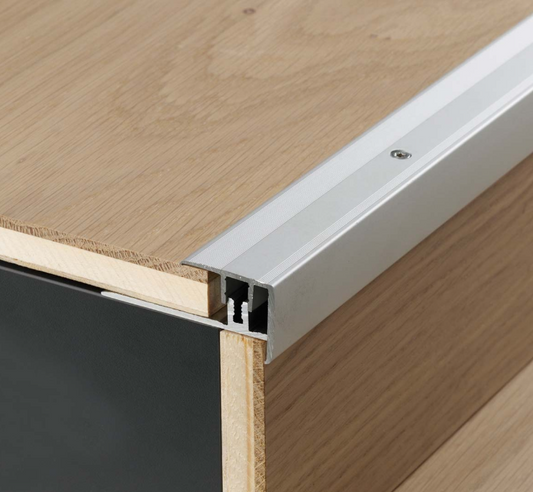 Close-up of a wooden floor stair and a  transition strip between two steps