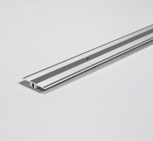 Metallic strip floor prifile on a light gray background