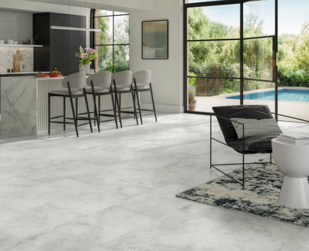 Modern living room with white marble-like flooring and a view of a pool and garden.