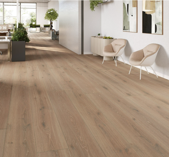 Extra-long Parador Oak Castell Limed laminate flooring installed in a spacious modern-style living room with plant.