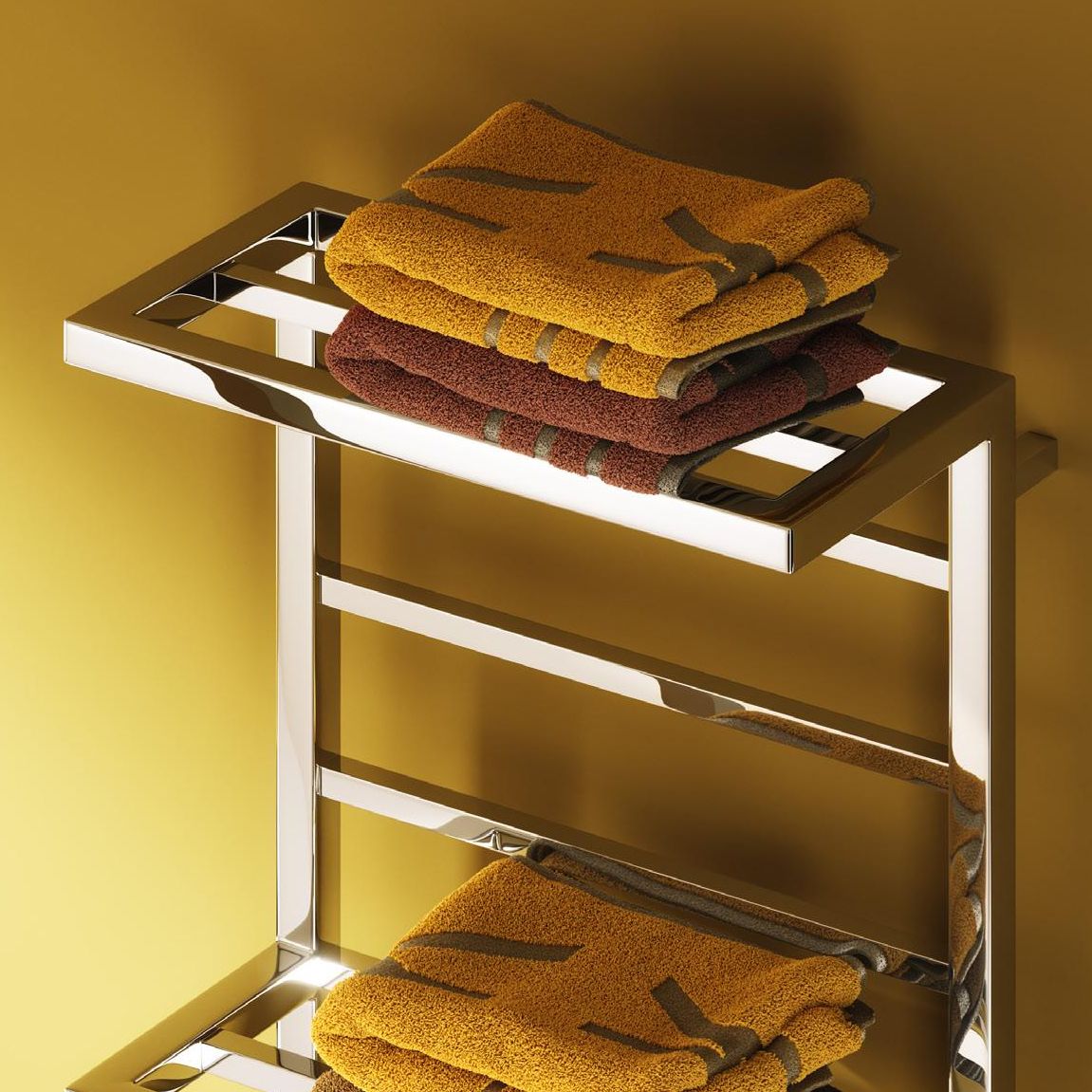Metal towel rack with folded towels on a yellow background